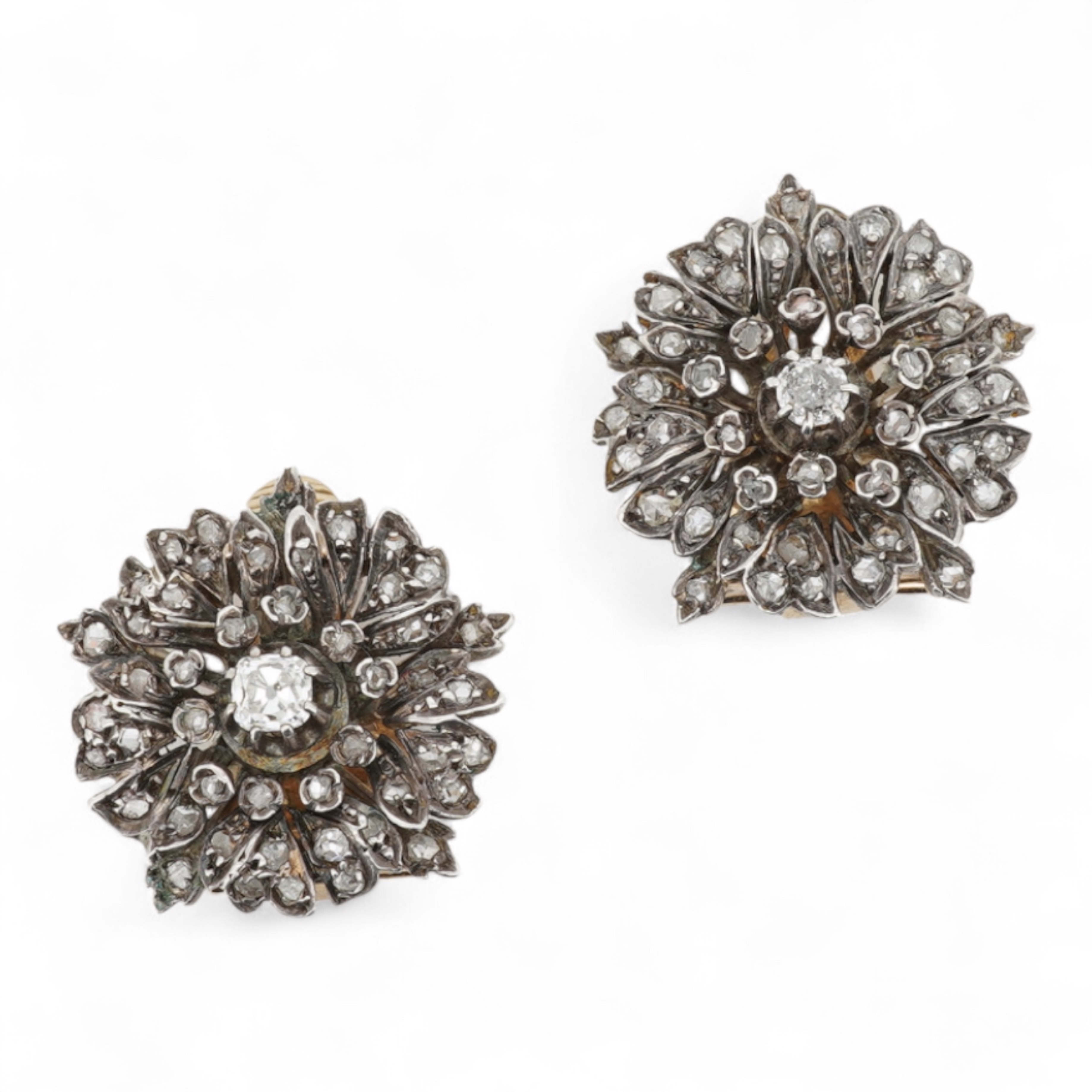 A pair of diamond ear clips 19th century and later, each designed as a wild rose, set with cushion-shaped and rose-cut diamonds, mounted in silver and gold, length 2.2cm each, later clip fittings